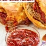 A bowl of homemade Arby's red ranch sauce in a small bowl and two roast beef sandwiches.