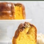 Bacardi rum cake slice and the cake behind it on a cake stand.