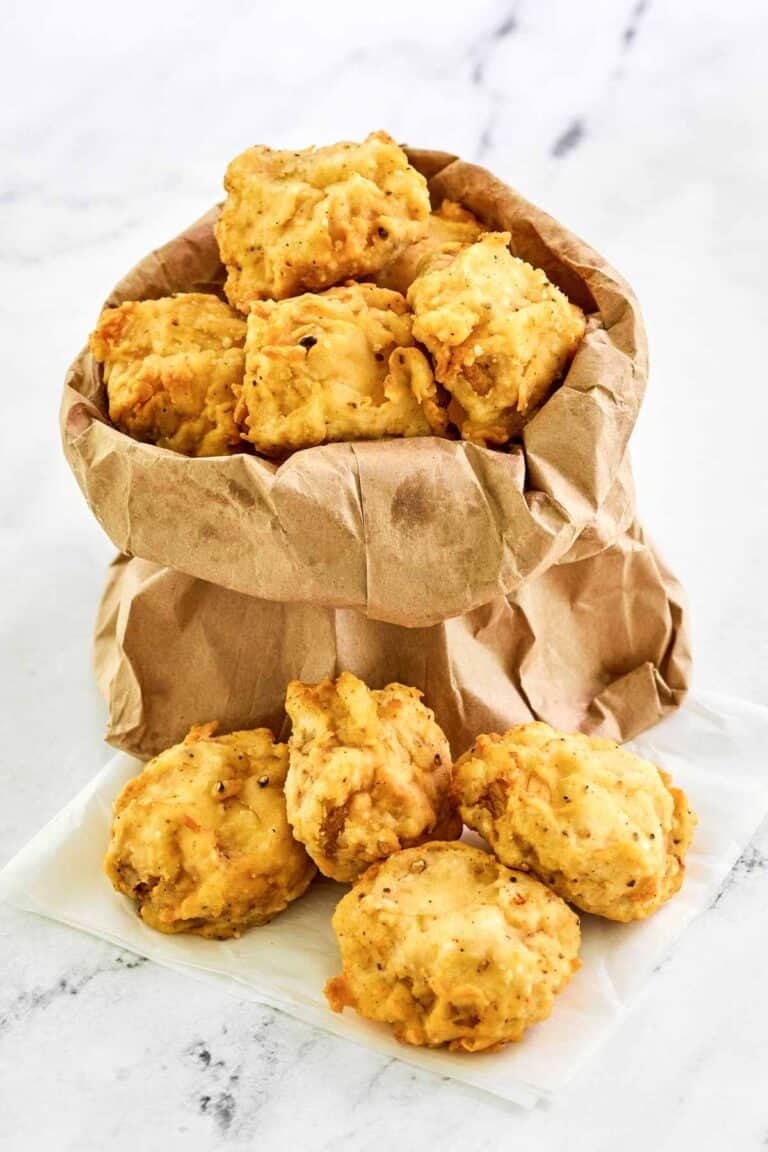 Copycat Fat Ronnie's deep fried mushrooms in a small paper bag and on parchment paper.