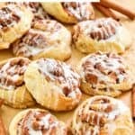 Homemade IKEA cinnamon rolls scattered on parchment paper.