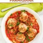Homemade Olive garden meatballs parmigiana and a fork on a cloth napkin.