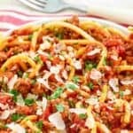 Copycat Olive Garden spice three meat sauce served with bucatini pasta.