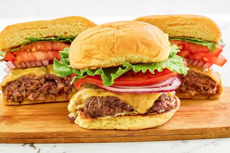 Two copycat Smashburger classic smash burgers on a serving board.