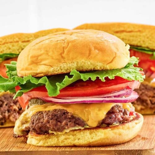 Copycat Smashburger classic smash burger on a small wood serving board.