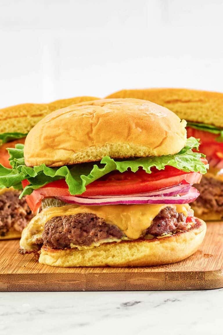 Copycat Smashburger classic smash burger on a small wood serving board.