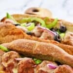 Two copycat Subway meatball sub sandwiches on a wood board.