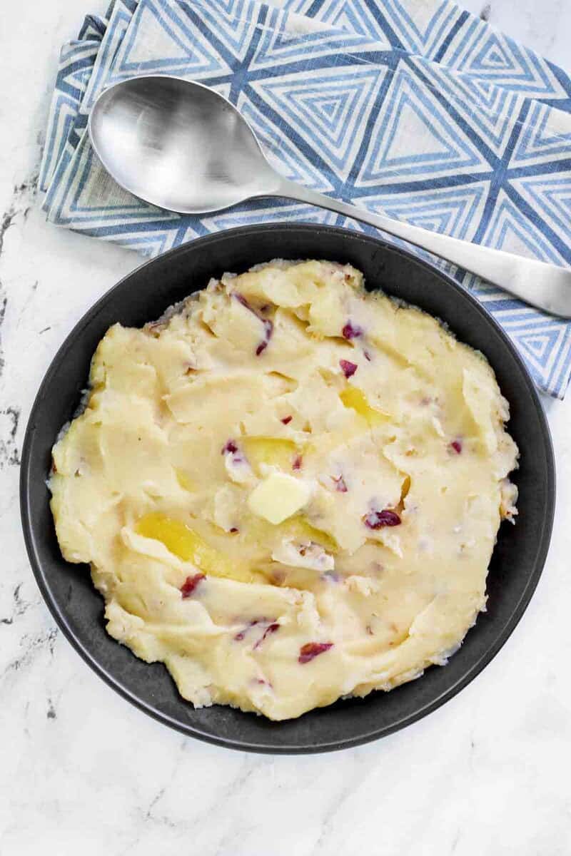 Copycat Cheesecake Factory mashed potatoes in a large bowl and a serving spoon by it.
