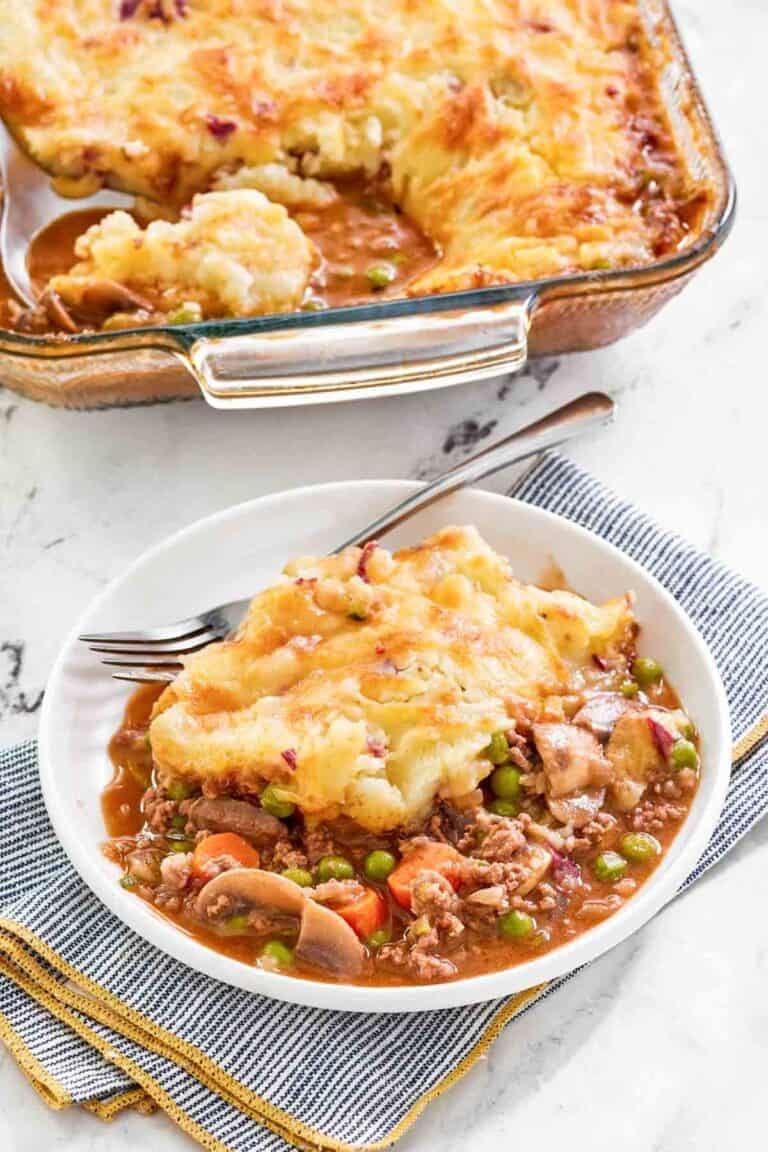Copycat Cheesecake Factory shepherd's pie serving on a plate and the pie in a baking dish.