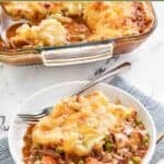 Homemade Cheesecake Factory shepherd's pie in a baking dish and a serving on a plate in front of it.