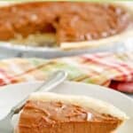 A slice of homemade chocolate cream pie on a plate in front of the pie.