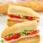 Copycat Kmart sub sandwich cut in half and another behind it wrapped in plastic.