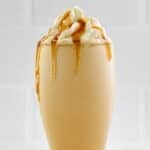 Homemade McDonald's caramel frappe in a tall glass.