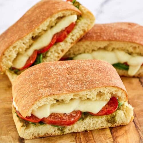 Copycat Starbucks tomato and mozzarella on focaccia sandwiches on a wooden board.