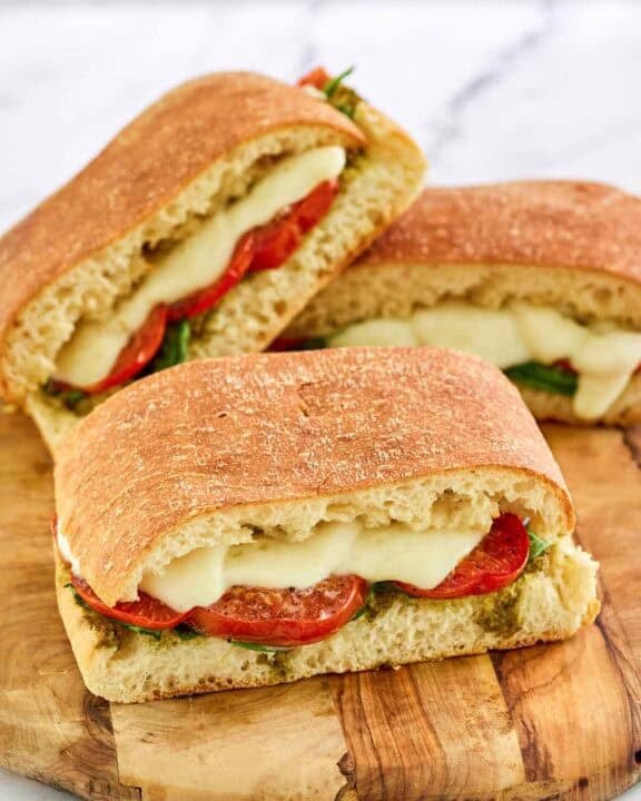 Copycat Starbucks tomato and mozzarella on focaccia sandwiches on a wooden board.