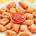 Copycat Totino's pepperoni pizza rolls and a cups of marinara on a platter.