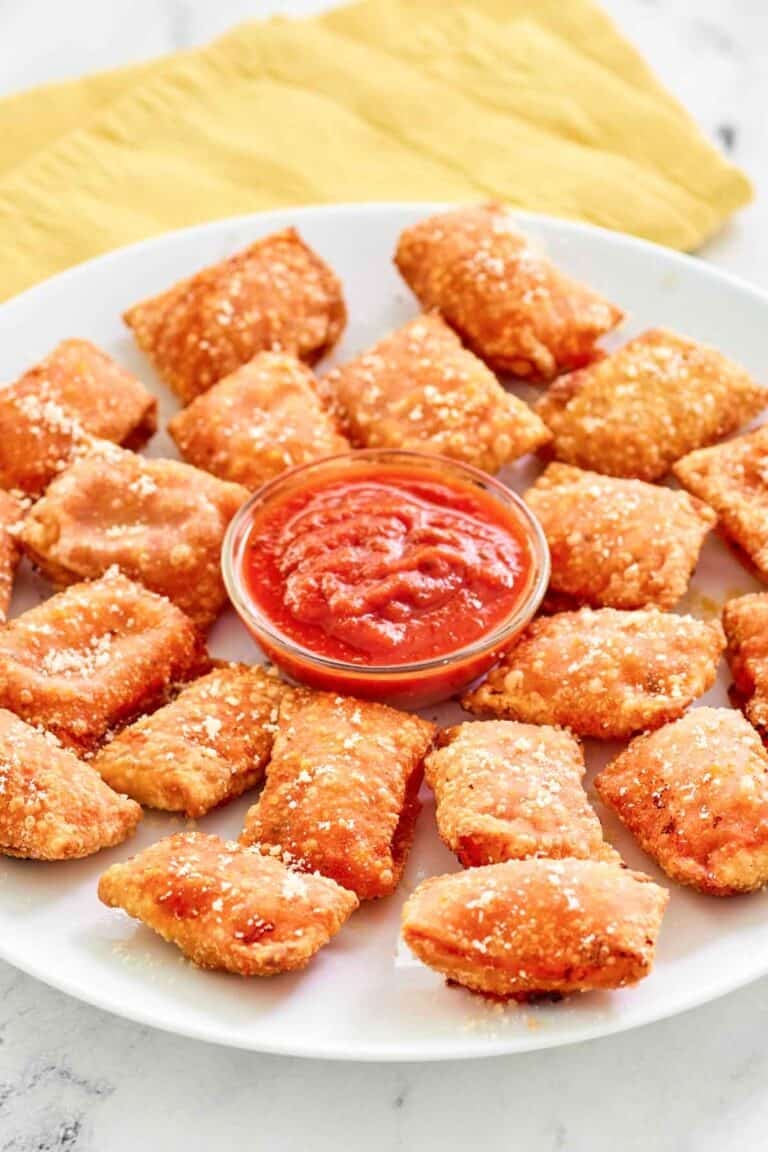 Copycat Totino's pepperoni pizza rolls and a cups of marinara on a platter.