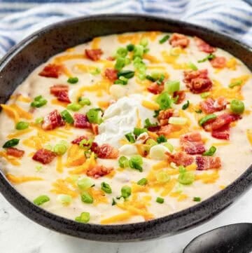 Copycat Black Angus Steakhouse baked potato soup and a spoon in front of it.