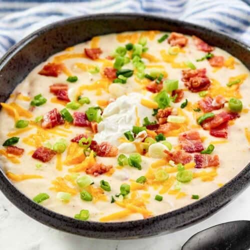 Copycat Black Angus Steakhouse baked potato soup and a spoon in front of it.