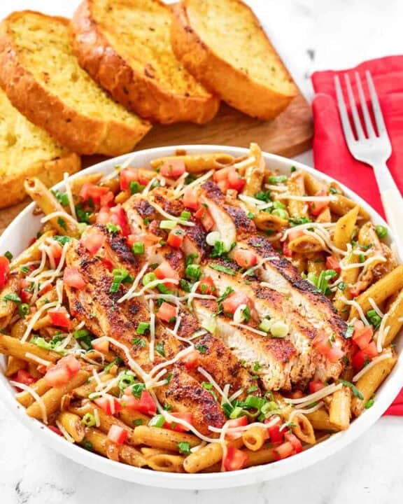 Copycat Chili's cajun chicken pasta served with garlic bread.