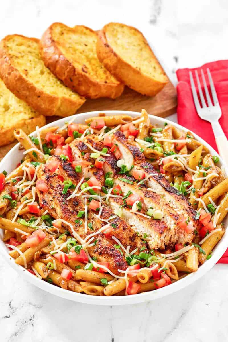 Copycat Chili's cajun chicken pasta served with garlic bread.
