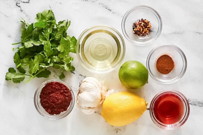 Copycat Chipotle Mexican Grill red chimichurri sauce ingredients on a marble surface.