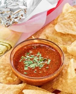 Copycat Chipotle Mexican Grill red chimichurri sauce served with chips and a burrito.