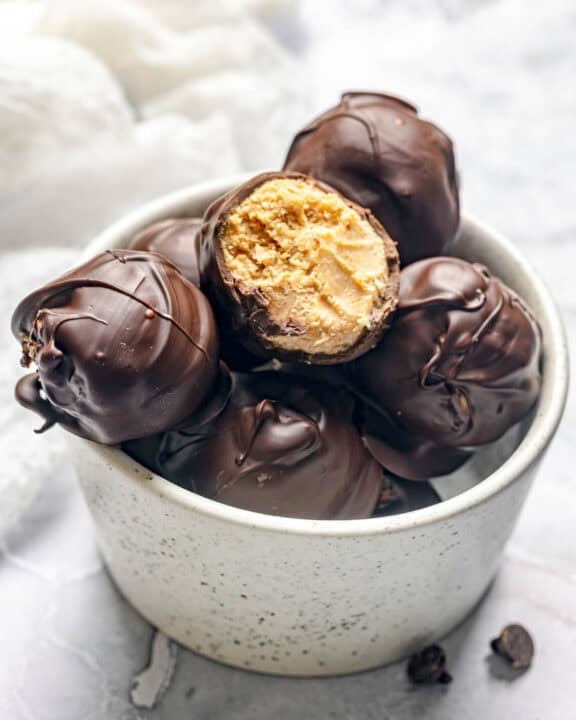 Homemade chocolate peanut butter balls in a bowl.