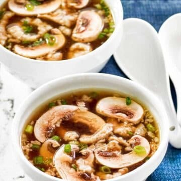 Homemade Japanese clear soup in two bowls and two soup spoons beside them.