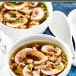 Bowls of homemade Japanese clear soup and soup spoons next to them.