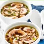 Two bowls of Japanese clear broth soup with scallions and mushrooms.