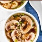 Bowls of homemade Japanese clear broth soup with mushrooms and scallions.