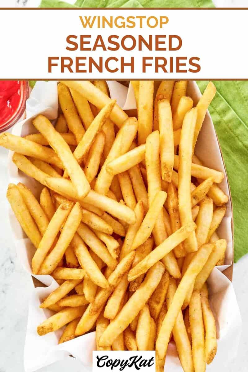 Homemade Wingstop seasoned French fries, a small cup of ketchup, and a cloth napkin.