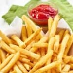 Homemade Wingstop seasoned French fries in a parchment paper lined basket.