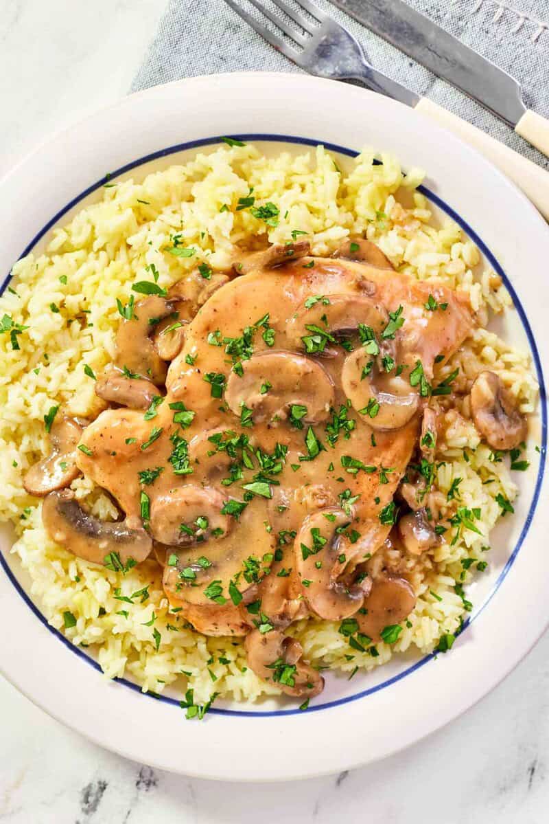 Copycat Cracker Barrel chicken and rice with mushroom gravy garnished with parsley.