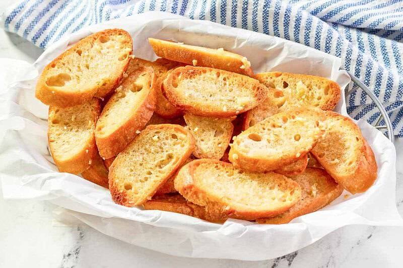 Copycat Jason's Deli garlic toast in a serving basket and a kitchen towel behind it.