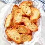 Homemade Jason's Deli garlic toast in a serving basket on a marble surface.