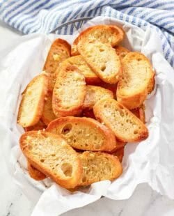 Homemade Jason's Deli garlic toast in a serving basket on a marble surface.