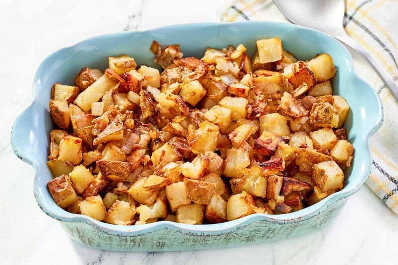 Lipton onion soup mix roasted potatoes in a ceramic serving dish on a marble surface.