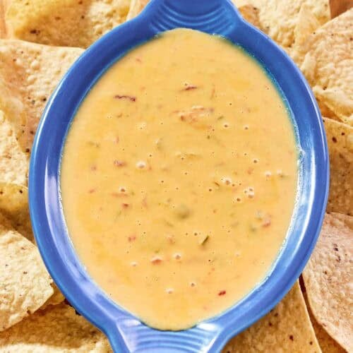 Spicy Rotel dip and tortilla chips on a wood platter.