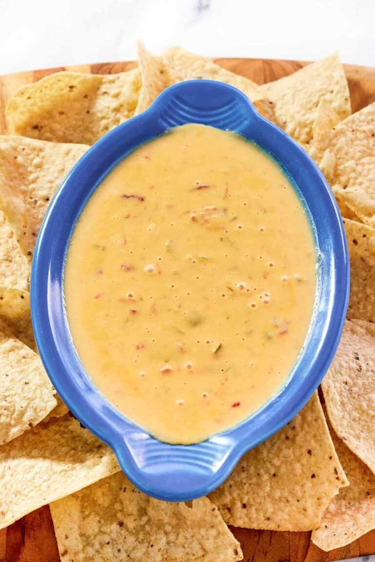 Spicy Rotel dip and tortilla chips on a wood platter.