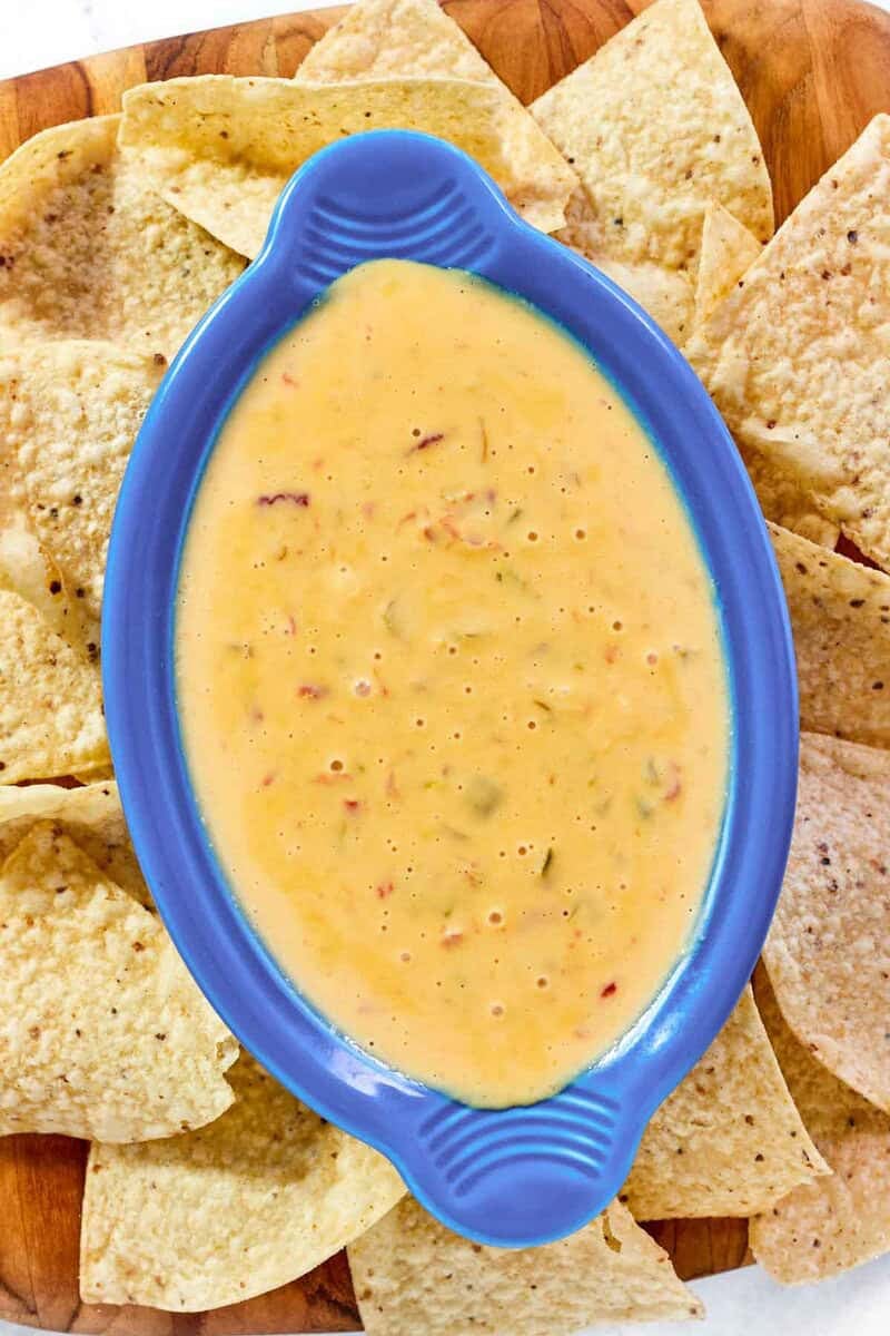 Spicy Rotel dip in a small serving dish and tortilla chips around it.