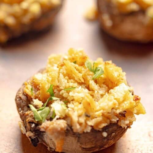 Stuffed mushrooms with Ritz crackers on a wood platter.