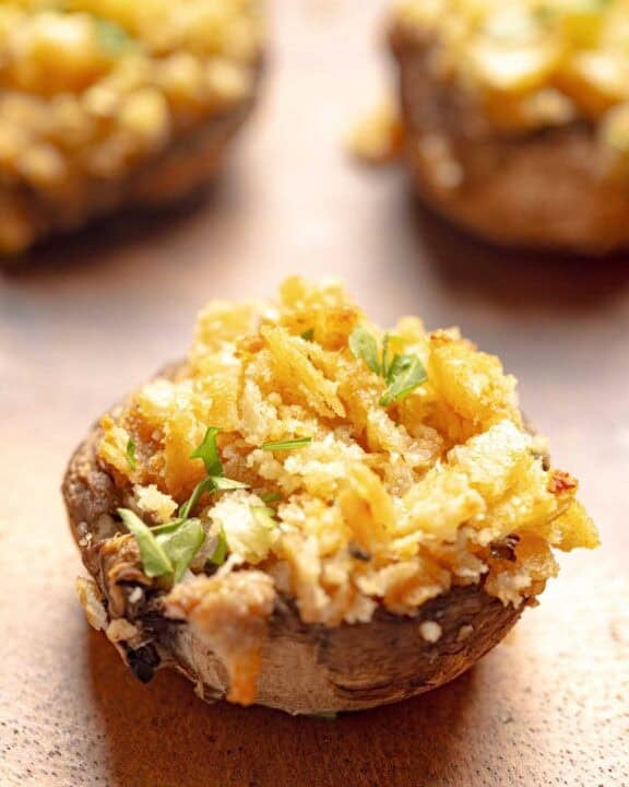 Stuffed mushrooms with Ritz crackers on a wood platter.