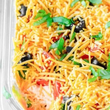 Homemade 7 layer dip in a glass dish.