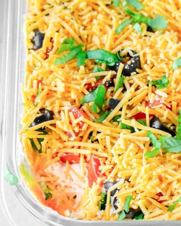 Homemade 7 layer dip in a glass dish.