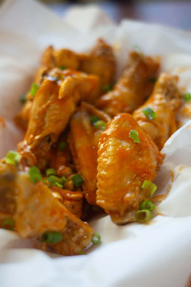 Air fryer garlic buffalo chicken wings in a basket.