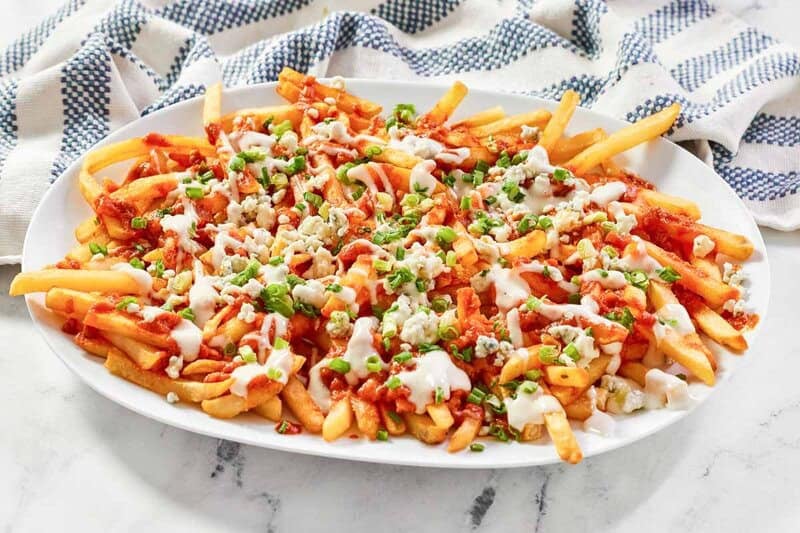 Buffalo fries on a platter and a kitchen towel behind it.