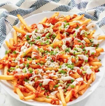 A platter of buffalo fries on a marble surface.