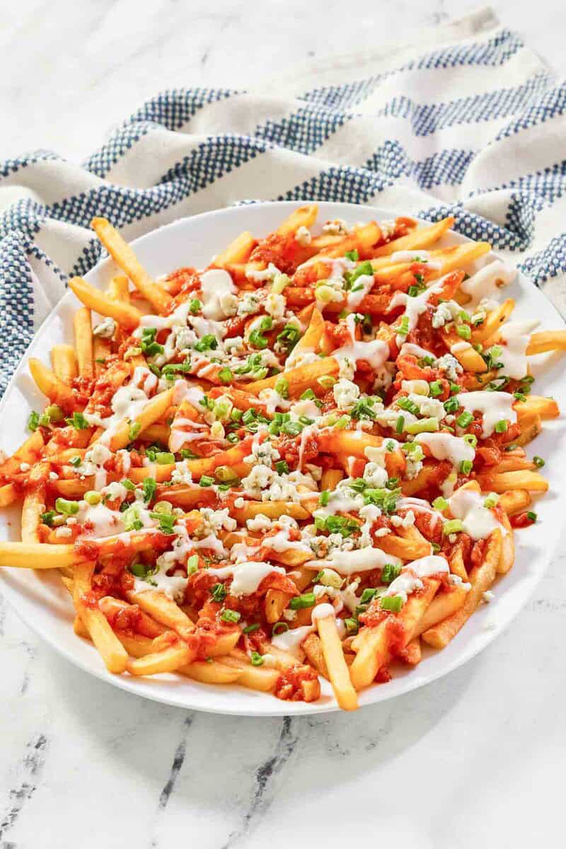 A platter of buffalo fries on a marble surface.