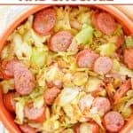 Overhead view of a bowl of southern fried cabbage with sausage and bacon.